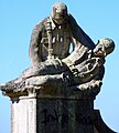 Soldado sujetando a un compañero caído, a la izquierda del monumento