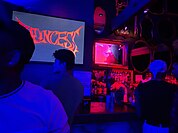 Photograph of a busy bar under red lighting