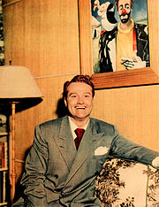 Skelton at home with one of his clown paintings, 1948