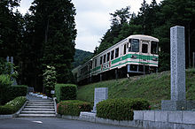 A train passing the memorial at the site of the 1991 crash SKR Shigaraki train disaster site.jpg