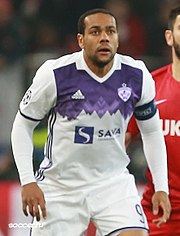 An Afro-Brazilian man in a white and purple football kit.