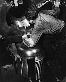 Welin breech-block of a 16-inch Mk 6 gun on USS Alabama (BB-60), 1943. Note the four separate thread "steps" on the block which engage with matching steps in the breech when the block is swung up and inwards and rotated slightly clockwise Sailor looking into the breech of 16 inch gun aboard USS Alabama (BB-60).jpg