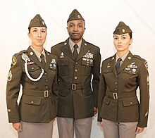 The Army Green Service Uniform Soldier models pose in the final prototypes of the proposed "pinks and greens" dress uniforms. A skirt and pumps would be optional for women. (Army).jpg