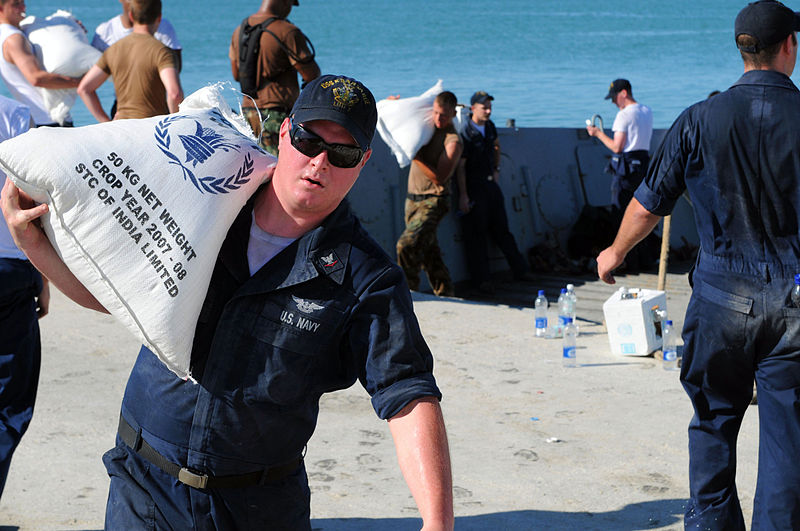File:US Navy 080915-N-7955L-072 Aviation Boatswains Mate (Handling) 3rd Class Jordan Garret carries rice from a landing craft during a humanitarian assistance mission in Haiti.jpg