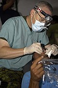 US Navy 090627-F-7923S-069 Maj. Don Trider, a Canadian dentist, provides dental care for a Salvadoran man at Centro Escular Ramon Mendoza school.jpg