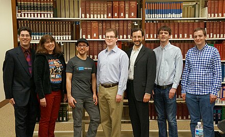 A group of Wikimedians of the Wikimedia DC chapter at the 2013 DC Wikimedia annual meeting standing in front of the Encyclopædia Britannica (back left) at the US National Archives