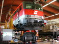 English: (missing text) 1142 602-0 jacked up in the workshop of Selzthal station, under the locomotive a single AC motor with wheelset can be seen. Deutsch: (missing text) 1142 602-0 aufgebockt in der Werkstätte in Selzthal. Unter der Lok liegt ein Wechselstrom-Antriebsmotor mit Rädern.