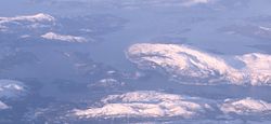 Luftfoto taget fra øst. Terråkfjorden ligger til venstre for øen Øksninga. Øksninga har en skæv L-form og er lidt til venstre for midten af billedet. Til højre for øen ligger Reppsundet. Videre mod højre går Tosen