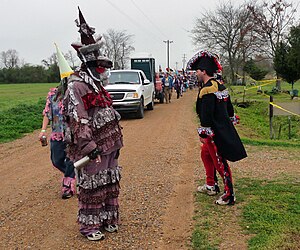 A traditional Cajun Courir de Mardi Gras costume based on a Rougarou (figure on left) Courir de Mardi Gras Savoy Rougaroo and Capitane 2011.jpg
