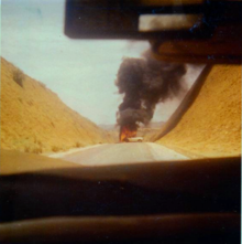 Burning MPLA staff car destroyed in the fighting outside Novo Redondo, late 1975 FAPLA car burning.PNG