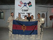 Members of the Canadian Grenadier Guards pose at Camp Nathan Smith, Afghanistan, with the regiment's flag, which bears the double mirrored Royal Cypher of Queen Elizabeth II, ER, beneath a St. Edward's Crown all within a wreath of maple leaves; 3 February 2008 GuardFlagKandahar.jpg