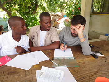 A French-speaking Canadian volunteer helps two...