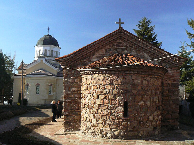 Patio de un monasterio ortodoxo con una pequeña iglesia medieval a la derecha y una más moderna a la izquierda.