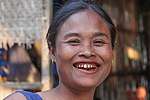 Lao woman with the characteristic red-stained teeth and gums from chewing betel nut