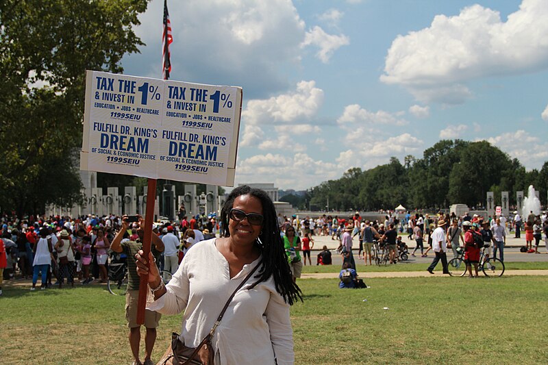 File:Marcher with SEIU 1199 union sign and white blouse.jpg