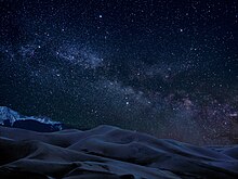 The Milky Way shines above the dunes. Great Sand Dunes is an International Dark Sky Park. Milky Way over dunes in Great Sand Dunes National Park, Colorado, United States.jpg