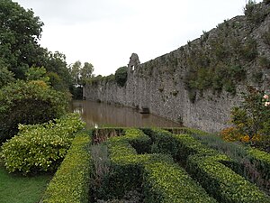 Olveston Court, view of remnant of moat and crenellated wall, situated immediately to the left of the gatehouse as depicted above by Loxton OlvestonCourtMoat.jpg