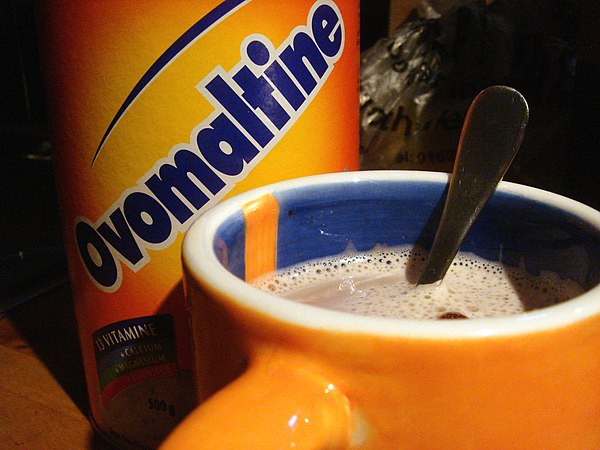 Ovaltine jar and cup, both in the distinctive orange colour