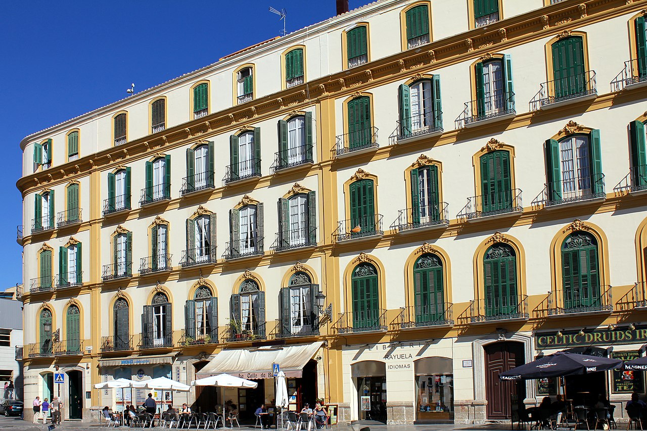 4-storey building where Picasso was born with yellow window arches and green shutters.