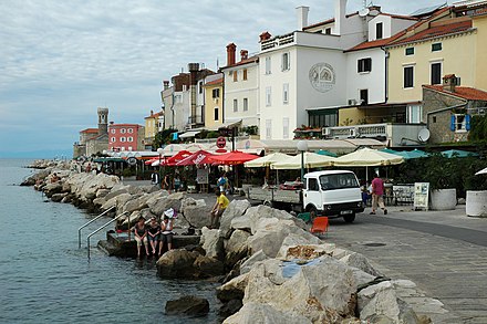 Piran's coast with colourful buildings, swimming piers and restaurants
