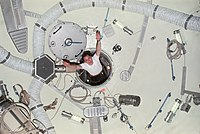 Edward Gibson seglande genom en luftsluss på Skylab 4.