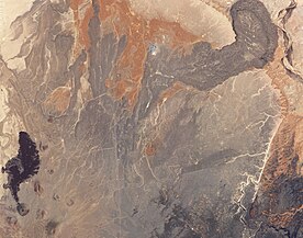 Forming a paisley pattern, the dark volcanic rocks north of SP Crater (bottom left) result from lava flows.