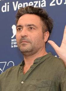 Saverio Costanzo facing right of the camera, waving at an audience