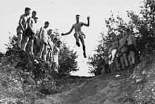 Teilnehmer einer der ersten Ausbildungen an der Eidgenössischen Hochschule für Sport EHSM springen als Mutprobe in eine Kiesgrube.