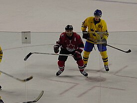 Фотография Айзермана в костюме Канады рядом со шведским игроком через защитное стекло.