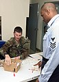 US Navy 060112-N-5686B-002 Afloat Training Group Western Pacific's assistant command urinalysis coordinator Master-at-Arms 1st Class Robert Rokeach receives a urine sample.jpg