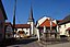 Eine Kreuzgruppe an der Hauptstraße in Wattendorf, im Hintergrund die Kirche St. Barbara.