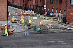 Construction workers blasting water on a closed-off section of Princes Dock Street adjacent to the A63 in Kingston upon Hull.