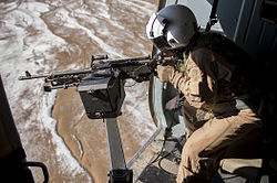 Бортовой стрелок 7,62-мм пулемёта M240, установленного на легкосъёмной шкворневой установке в дверном проёме вертолёта Ми-17 Национального воздушного корпуса Афганистана (Кабул, 2012 год)