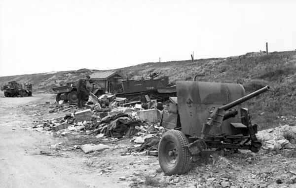 A destroyed British gun and Bren carrier on the side of a road outside Calais.