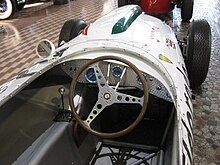 A spartan cabin for the driver with only rudimentary instruments and controls. Visible chassis frame tubes. Collection Panini Maserati 0100.JPG