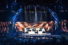 The stage with its movable parts and the audience closely surrounding it during the opening act of the second semi-final