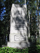 Un pedestal de piedra que conmemora la Guerra Civil con un escudo de armas recortado de Finlandia y la inscripción "Sacrificaron sus vidas por la patria y la libertad en 1918".