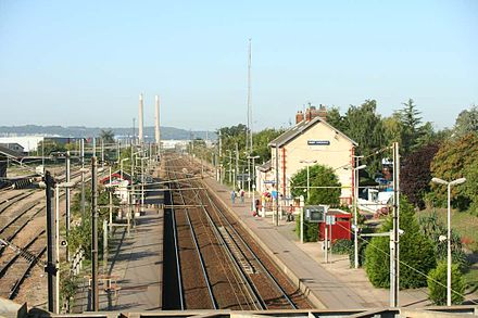 La gare SNCF. On aperçoit dans le fond les cheminées de la centrale thermique de Porcheville.