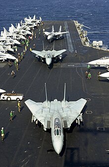 Photographie d'avions (Grumman F-14 Tomcat) sur le pont du porte-avion USS Enterprise.