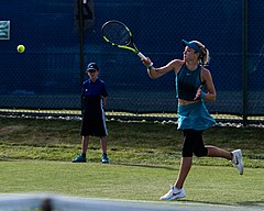 Katie Swan baring her midriff and outie belly button during a tennis match.