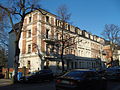 Double apartment building with fencing and side gate entrances, in open development