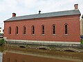 The Moody Street Feeder Gatehouse, built in 1848. Located on the north side of the intersection of Suffolk Street and Merrimack Street, on the west side of the canal.