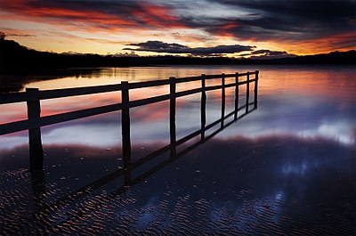 Matahari terbenam di Teluk Mortimer, South Arm, Tasmania, Australia.