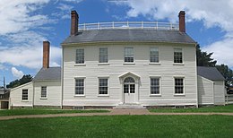 Foto van een twee verdiepingen hoog, wit clapboard huis