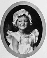 Smiling child in frock and cap