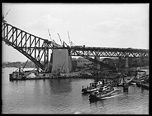 Vehicular ferries, Koondooloo and Kooroongaba at Jeffrey Street wharf, Kirribilli, with the Sydney Harbour Bridge under construction behind, 1930. Sydney Harbour Bridge under construction.jpg