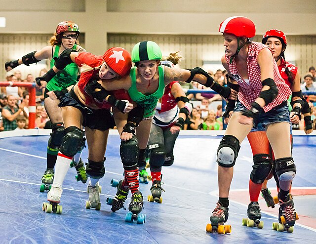 Lonestar Rollergirls in Austin, Texas, play on a banked track (2011). The jammer (wearing the starred helmet cover) is trying to pass a pivot (wearing
