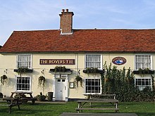 Outside view of a pub, with tables in the foreground