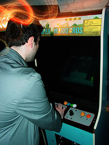 Homme jouant sur une borne d'arcade