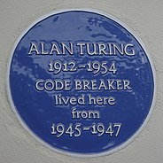 Una placa azul en una pared blanca con las palabras "Alan Turing 1912-1954 CODE BREAKER vivió aquí desde 1945 hasta 1947